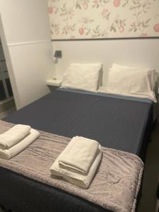 twee bedden in een kamer met handdoeken erop bij Liber Guest House in Braga