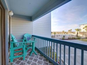 a balcony with a blue chair and a view of the ocean at Beach and Racquet in Tybee Island