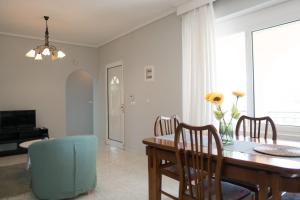 a dining room with a table and chairs and a television at Raptis Guest House in Tsilivi