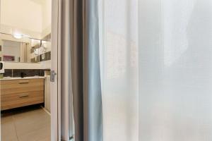 a bathroom with a sliding glass door to a kitchen at Mirabilia Golden in Bologna