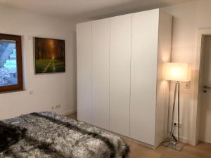 1 dormitorio con un gran armario blanco y una lámpara en 42up Berlin Pankow en Berlín
