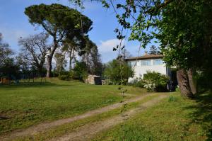 a house in a field with a dirt road at Agriturismo Tenuta Buon Respiro in Orvieto