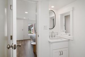 une salle de bain blanche avec un lavabo et un miroir dans l'établissement Hummingbird Cottage-MCA #50070, à Manzanita 17 autres photos