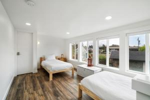 - une chambre blanche avec 2 lits et des fenêtres dans l'établissement Hummingbird Cottage-MCA #50070, à Manzanita