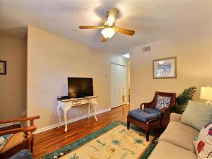 a living room with a ceiling fan and a tv at Donna`s Escape in Tybee Island