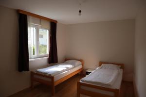 two beds in a room with a window at Lotus Villas in Travnik