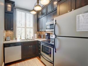 a kitchen with black cabinets and a refrigerator at Charm on Liberty in Savannah