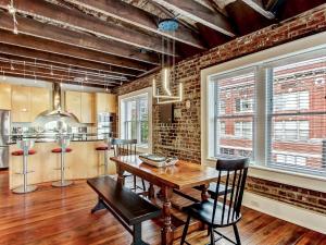 a dining room with a wooden table and chairs at Broughton Corner Loft in Savannah