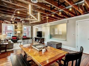 uma sala de estar com uma mesa de madeira e um sofá em Broughton Corner Loft em Savannah