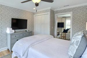a bedroom with a bed and a flat screen tv at El Rey Collection 2 in Tybee Island