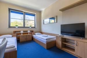 a room with two beds and a flat screen tv at Gdańska Szkoła Szermierki in Gdańsk