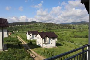 a group of white houses in a green field at Lotus Villas in Travnik