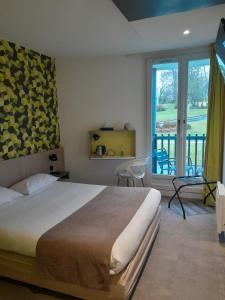1 dormitorio con cama grande y ventana grande en The Originals City, Ara Hôtel, Landerneau, en Landerneau