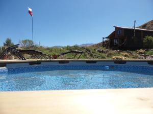 a large swimming pool in front of a house at Tierras Bayas Mountain Refuge in Los Cipreses