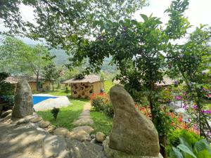 Sapa Bamboo Eco في سابا: حديقة بها صخور وساحة بها منزل