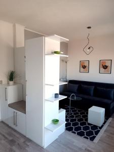 a living room with a black couch and a white cabinet at Apartman Daniela in Sarajevo