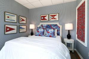 Un dormitorio con una cama blanca y algunas fotos en la pared en El Rey Collection 1, en Tybee Island