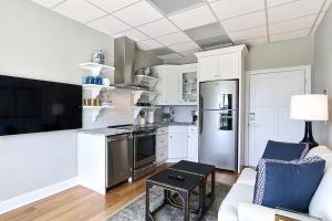 a kitchen with white cabinets and a stainless steel refrigerator at El Rey Collection 1 in Tybee Island