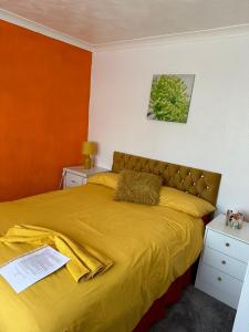 a bedroom with a bed with a yellow bedspread at Quick Stop Night Stay - Gatwick in Crawley