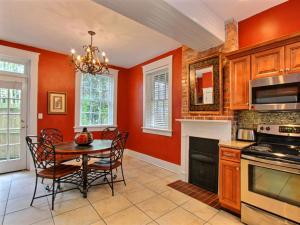 eine Küche mit orangefarbenen Wänden sowie einem Tisch und Stühlen in der Unterkunft Forsyth Park West Estate in Savannah