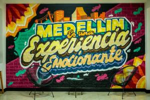 une fresque murale avec deux chaises devant elle dans l'établissement Mándala Hotel Belén, à Medellín