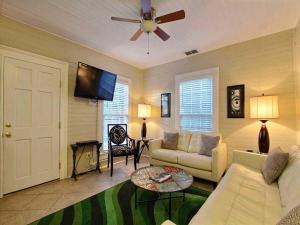 un soggiorno con divano e ventilatore a soffitto di Forsyth Park West Carriage House a Savannah