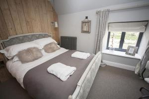 a bedroom with a bed with two towels on it at Timbrell's Yard in Bradford on Avon