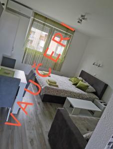 Habitación con cama, mesa y sofá en Studio apartmani Manila -bazeni, popust, Terme -VAUČERI en Vrnjačka Banja