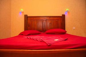 Cama roja con sábanas rojas y almohadas rojas en Hotel Janara en Kurunegala