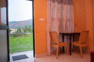 ein Esszimmer mit einem Tisch, Stühlen und einem Fenster in der Unterkunft Hotel Janara in Kurunegala