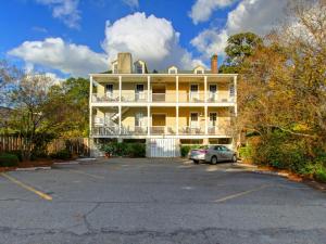 a large yellow building with a car parked in a parking lot at Bird Baldwin Parlor in Savannah