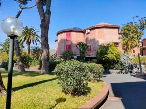 a building with palm trees and a street light at Villa Louise by Holiday World in Aci Castello