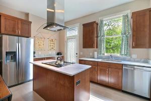 a kitchen with wooden cabinets and a stainless steel refrigerator at Change Of Place Main House in Savannah