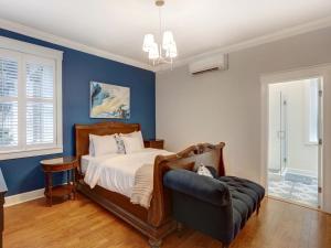 1 dormitorio con paredes azules, 1 cama y 1 silla en Liberty Street Retreat, en Savannah 21 fotos más