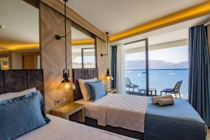 a bedroom with two beds and a view of the ocean at Class Unique Beach in Marmaris
