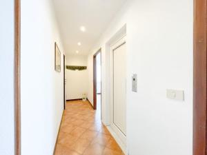 um corredor com uma porta branca e piso em azulejo em [Attico vista mare] ascensore in casa - WiFi - parcheggio gratis em Borghetto Santo Spirito