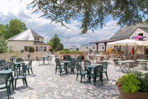 a patio with tables and chairs in a courtyard at Mobil-home 6/8 personnes - Camping Siblu **** Domaine de Dugny in Onzain