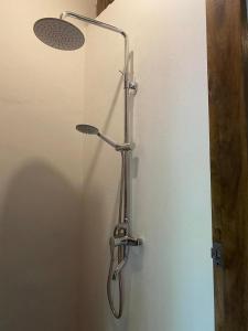 a shower in a bathroom with a light on the wall at Lexias Hostel and Workspace - Siargao in Catagnan