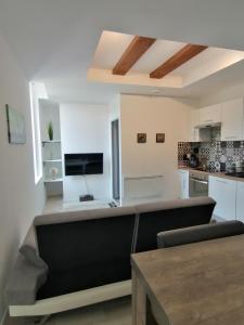 sala de estar con sofá y cocina en Jungle Zen Beau T2 avec jardin Gare 100m, en Tonneins