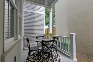 a patio with two chairs and a table on a porch at Congress Street Retreat in Savannah