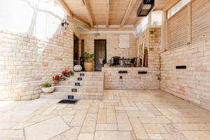 een overdekte patio met een stenen muur en een trap bij Charming Unit with Pool and Great Amenities in Rishon LeẔiyyon
