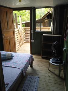 Schlafzimmer mit einem Bett und einer Tür zur Veranda in der Unterkunft Quarto do Madruga in Ilha do Mel