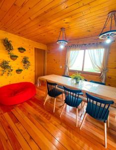 ein Esszimmer mit einem großen Holztisch und Stühlen in der Unterkunft Chalé Casa de campo para família! in Urubici