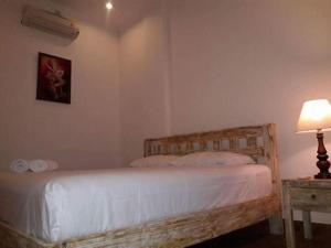 ein Schlafzimmer mit einem Bett und einem Tisch mit einer Lampe in der Unterkunft Private room in Damar Bali Guest house in Kerobokan