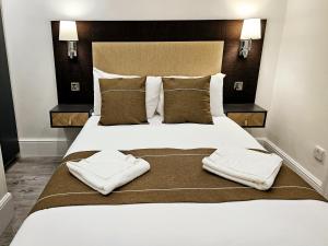 1 dormitorio con 1 cama grande y toallas. en Hyde Park Superior Apartments, en Londres
