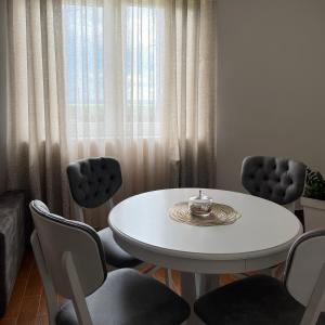 comedor con mesa blanca y sillas en Surčin Apartment en Ledine