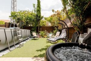 un jardín con bañera de hidromasaje en un patio en Charming Unit with Pool and Great Amenities, en Rishon LeZion