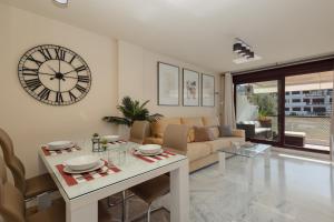 un soggiorno con un grande orologio sul muro di Apartment, with indoor pool, jacuzzi, sauna and gym, in Benahavis a Estepona