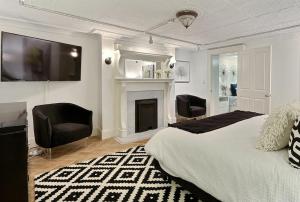 - une chambre avec un lit, deux chaises et une cheminée dans l'établissement Under The Red Door On Monterey, à Savannah