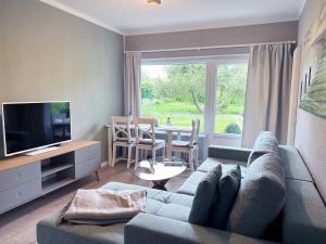 ein Wohnzimmer mit einem Sofa und einem TV in der Unterkunft Idyllische Ferienwohnung Schmidt 9226 - Burg in Fehmarn